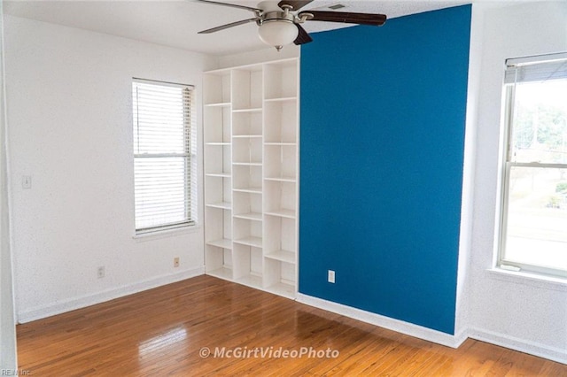 empty room with ceiling fan and hardwood / wood-style flooring