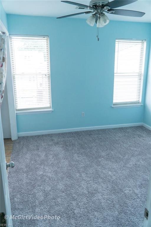 carpeted spare room with ceiling fan and a healthy amount of sunlight