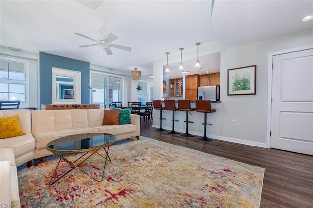 living room with ceiling fan and dark wood-type flooring