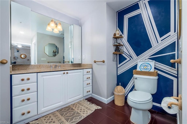 bathroom featuring a notable chandelier, tile patterned floors, vanity, and toilet