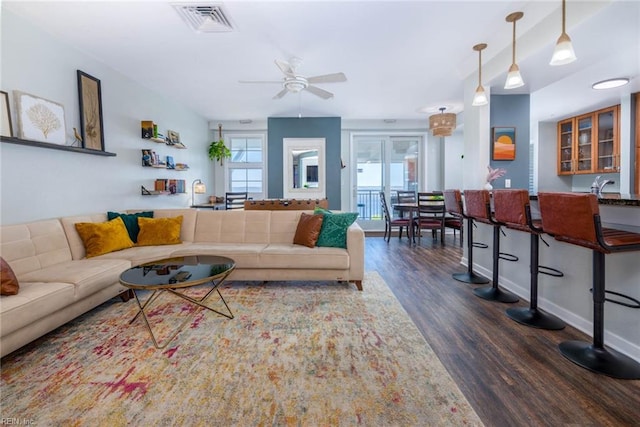 living room featuring ceiling fan and dark hardwood / wood-style floors