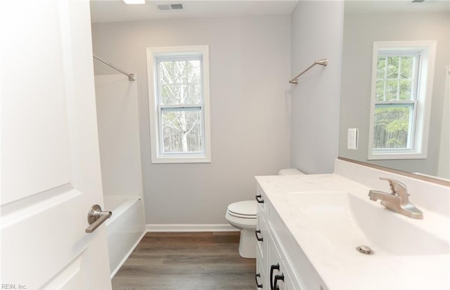 full bathroom with washtub / shower combination, vanity, wood-type flooring, and toilet