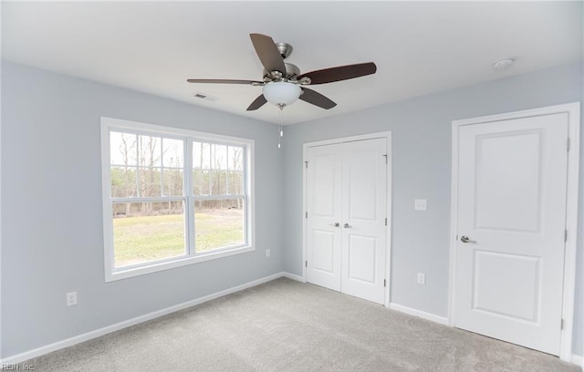 unfurnished bedroom featuring ceiling fan and light carpet