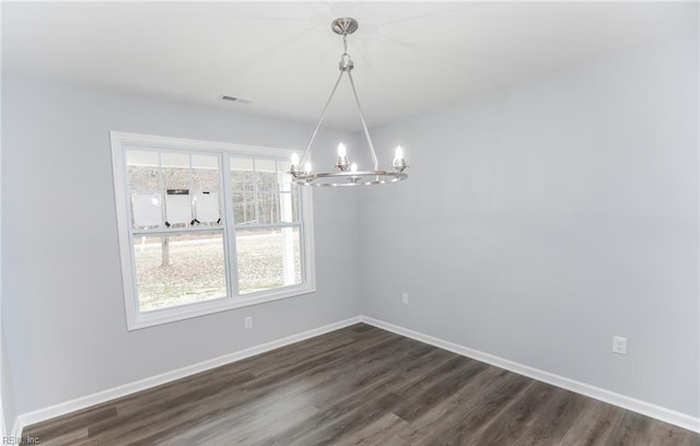 unfurnished dining area with dark hardwood / wood-style floors, an inviting chandelier, and a healthy amount of sunlight