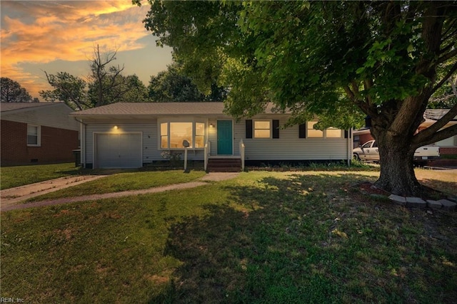 single story home featuring a lawn and a garage