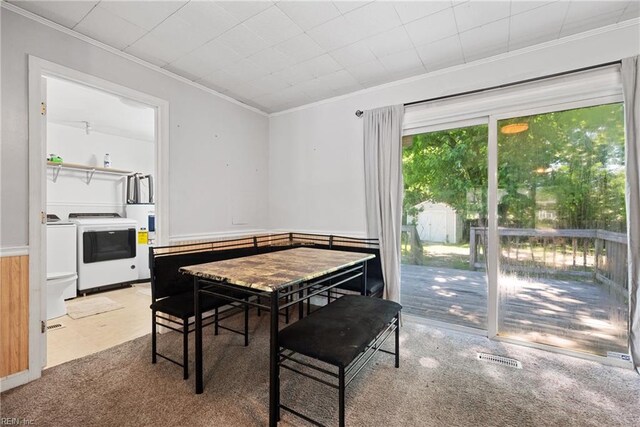 carpeted dining room with ornamental molding and independent washer and dryer