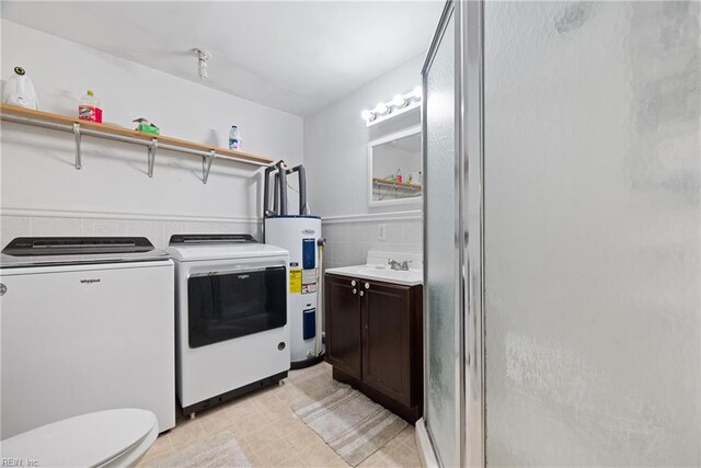 laundry area featuring sink, washer and dryer, and electric water heater