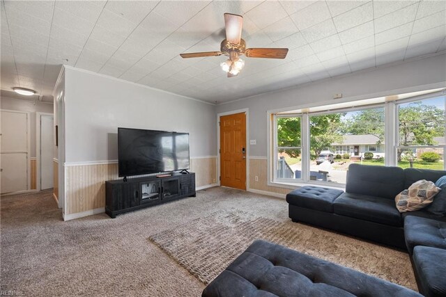 living room with ornamental molding, ceiling fan, and carpet floors