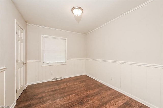 empty room featuring crown molding and dark wood-type flooring