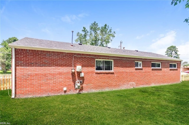 rear view of property featuring a lawn