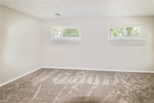 carpeted spare room featuring plenty of natural light