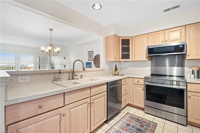 kitchen featuring stainless steel appliances, a chandelier, light brown cabinets, and sink