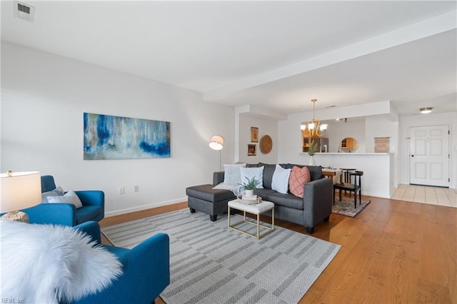 living room featuring a chandelier and light hardwood / wood-style floors