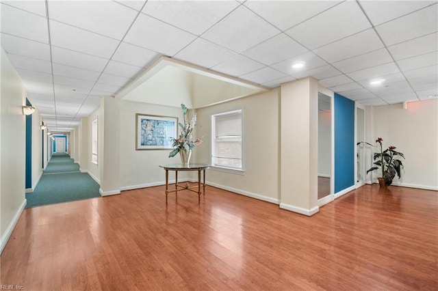 interior space with a paneled ceiling and hardwood / wood-style flooring