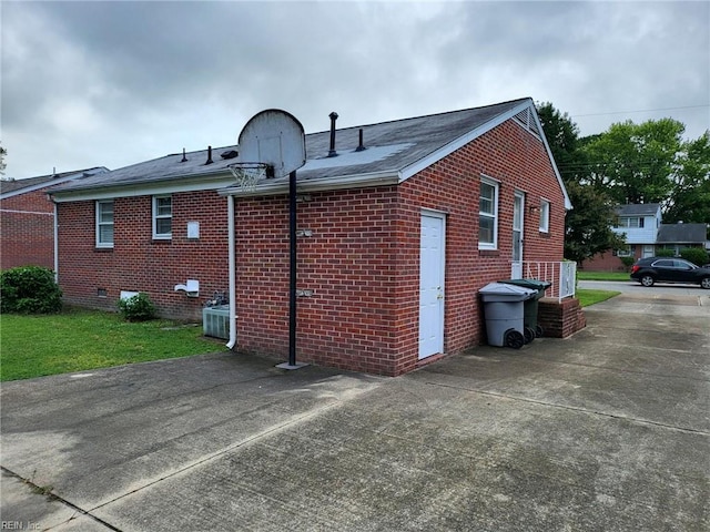 view of property exterior featuring cooling unit and a lawn