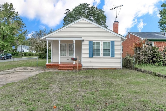 back of house featuring a porch and a yard