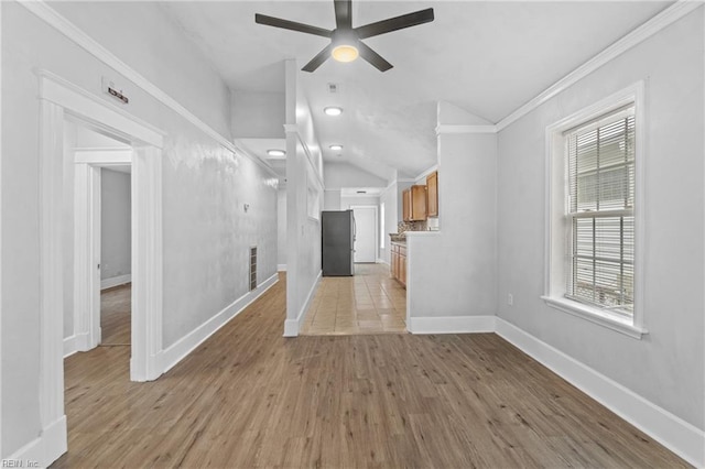 unfurnished living room with ceiling fan, vaulted ceiling, ornamental molding, and light hardwood / wood-style floors