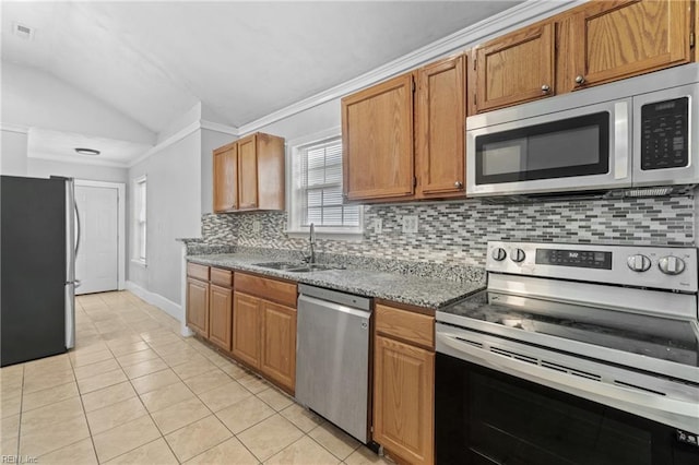 kitchen featuring lofted ceiling, light tile patterned floors, sink, tasteful backsplash, and appliances with stainless steel finishes