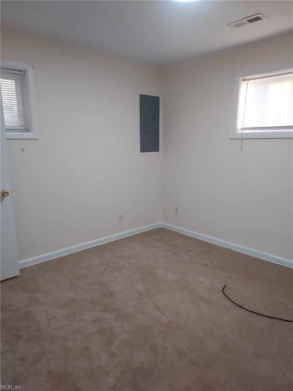 carpeted empty room with electric panel