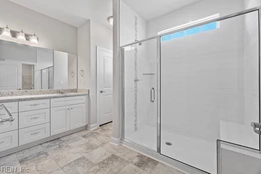 bathroom featuring vanity and a shower with door