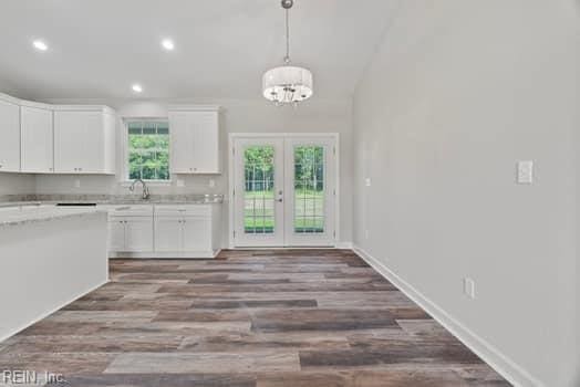 kitchen featuring french doors, pendant lighting, an inviting chandelier, white cabinets, and dark hardwood / wood-style floors