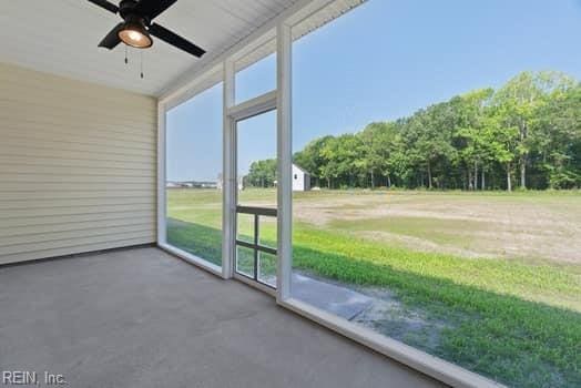 unfurnished sunroom featuring ceiling fan