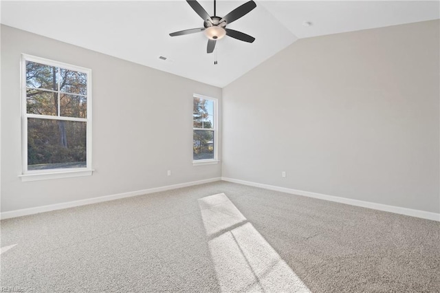 carpeted spare room with a wealth of natural light, ceiling fan, and lofted ceiling