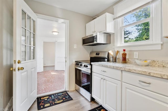 kitchen featuring white cabinets, appliances with stainless steel finishes, and light wood-type flooring