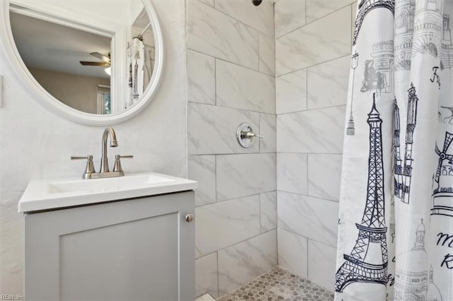 bathroom with ceiling fan, vanity, and curtained shower