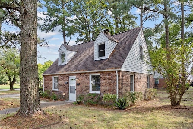 cape cod-style house with a front lawn