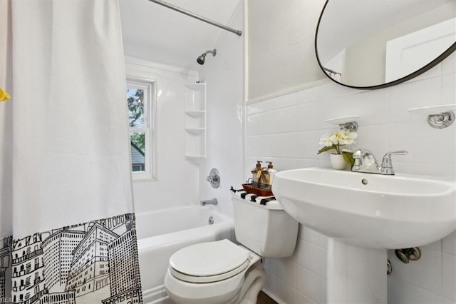 bathroom featuring tile walls, toilet, and shower / tub combo with curtain