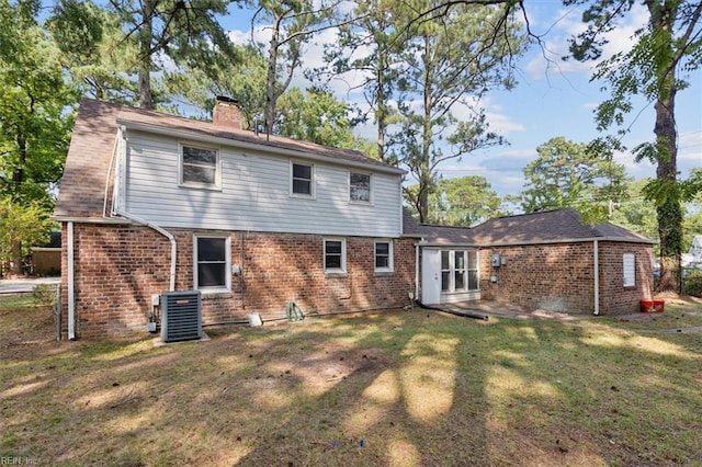 back of house with a yard and central air condition unit