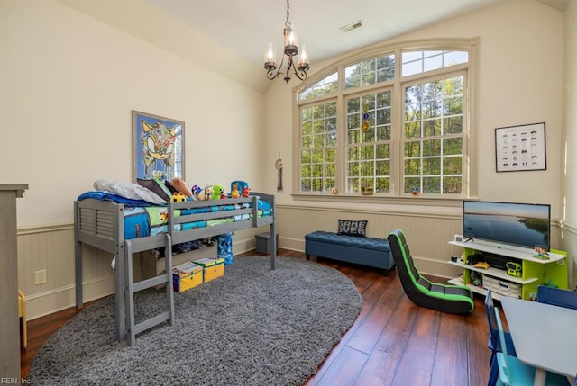 bedroom with an inviting chandelier, vaulted ceiling, and dark wood-type flooring