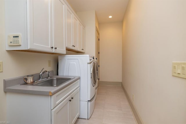 laundry area with sink, washer and dryer, and cabinets