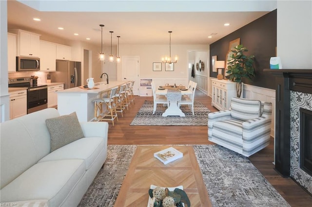 living room featuring dark hardwood / wood-style flooring, a notable chandelier, and sink