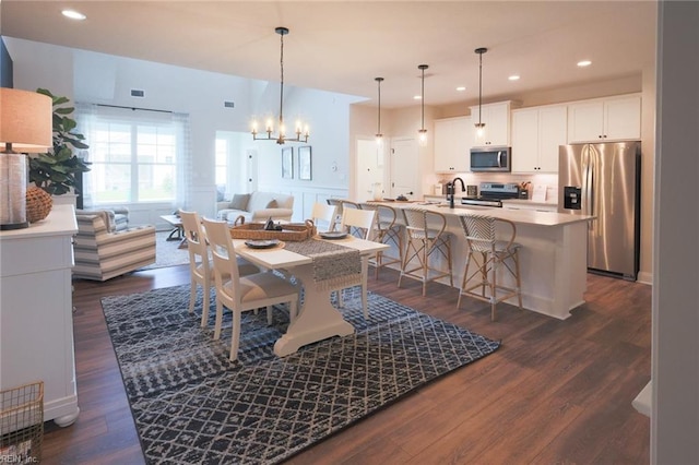 dining area with a chandelier and dark hardwood / wood-style flooring