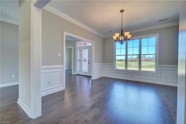 empty room featuring crown molding, dark hardwood / wood-style floors, and a notable chandelier