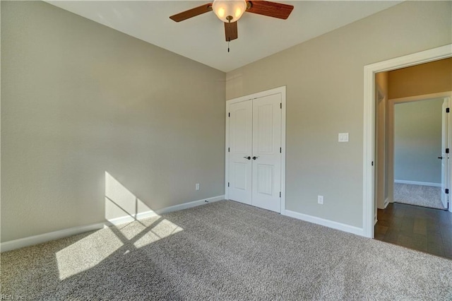 interior space with dark carpet, a closet, and ceiling fan