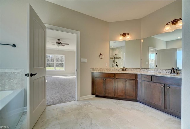 bathroom featuring ceiling fan, a bath, and vanity