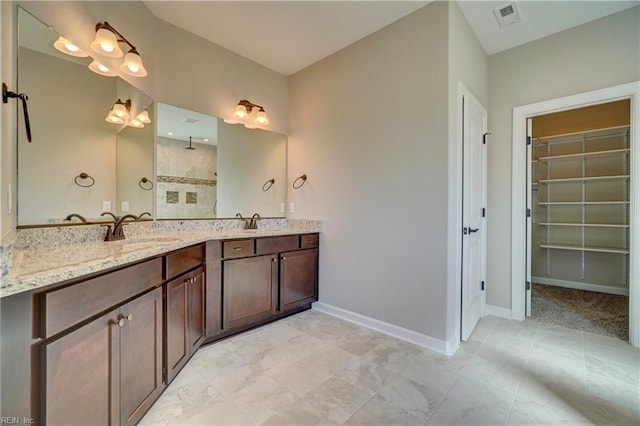 bathroom featuring walk in shower and vanity