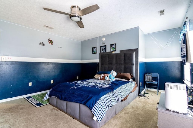 carpeted bedroom featuring a textured ceiling and ceiling fan