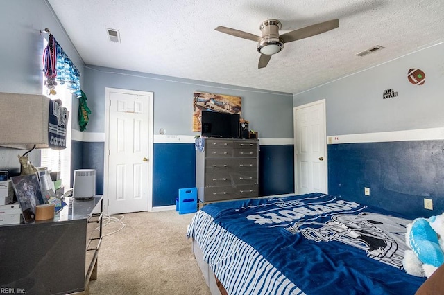 carpeted bedroom with ceiling fan, a textured ceiling, and multiple windows