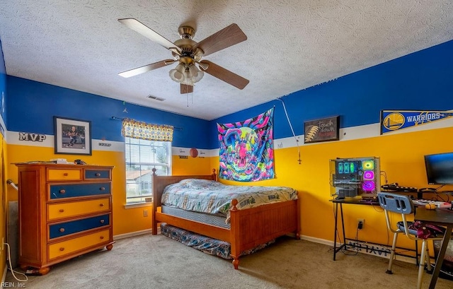 carpeted bedroom with ceiling fan and a textured ceiling