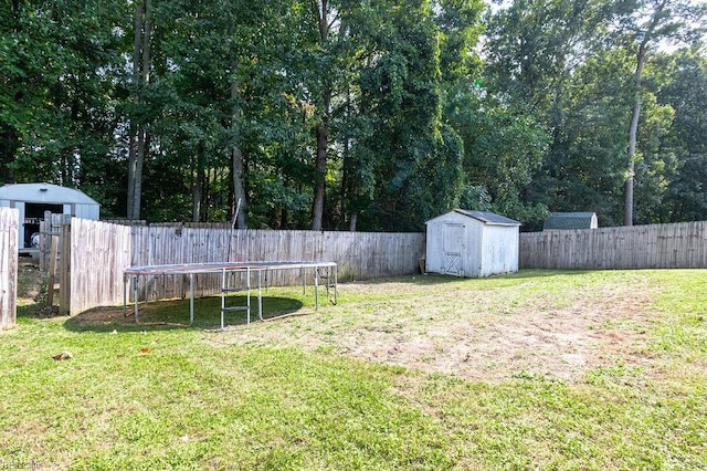 view of yard with a trampoline and a shed