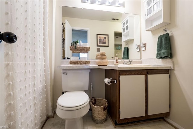 bathroom featuring curtained shower, vanity, toilet, and tile patterned floors