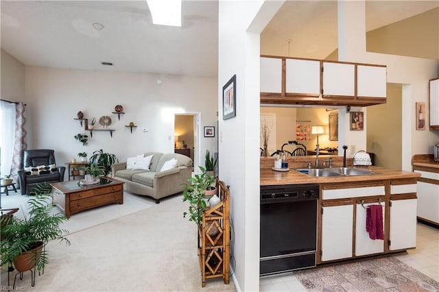 kitchen with light carpet, white cabinets, black dishwasher, and sink