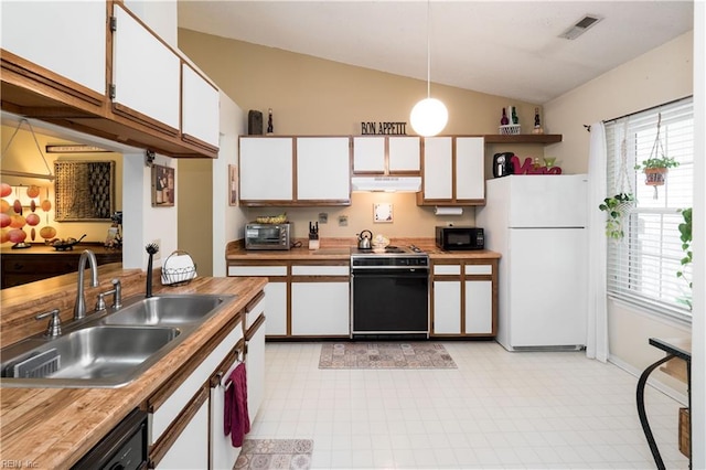 kitchen featuring black appliances, lofted ceiling, and white cabinets