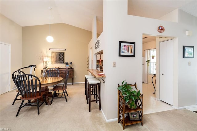 carpeted dining room featuring lofted ceiling