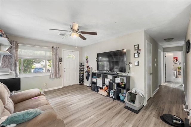 living room with light hardwood / wood-style floors and ceiling fan