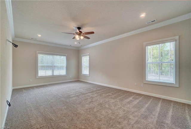 spare room with ceiling fan, crown molding, carpet, and a healthy amount of sunlight